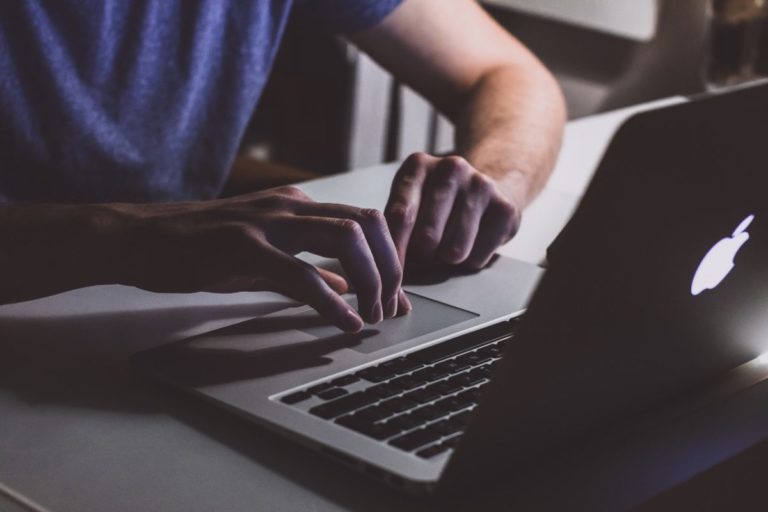 a person's hand on a laptop keyboard