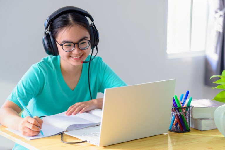 a woman wearing a headset and using a laptop