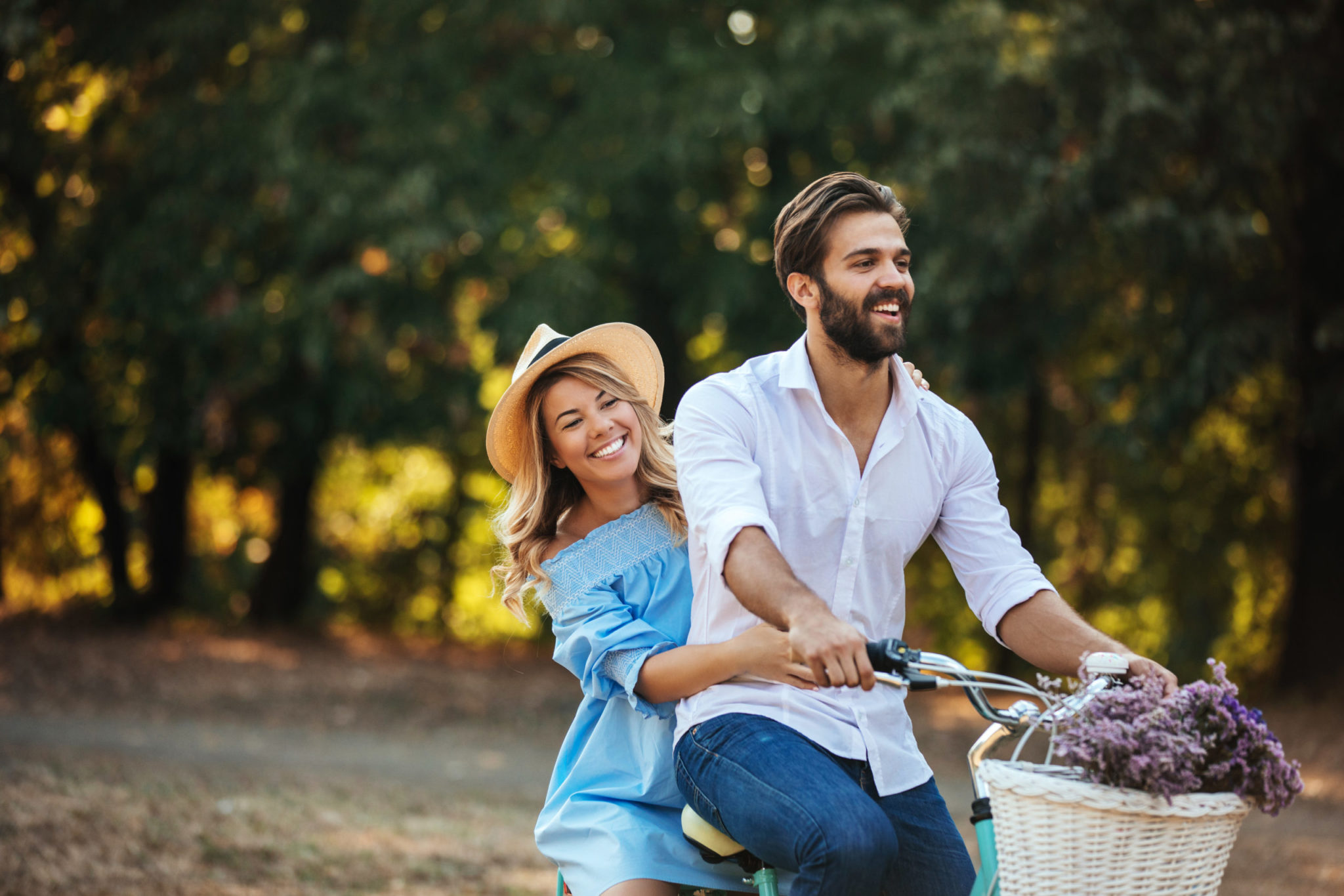 a person and a girl sitting on a bench with a basket of grapes