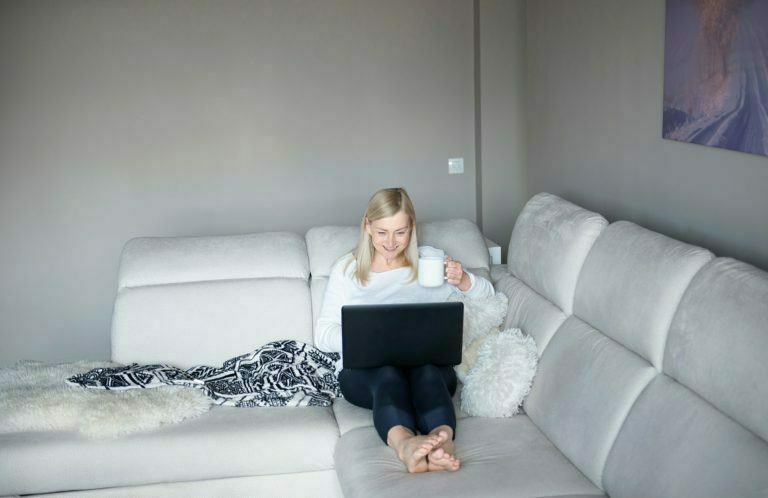 a person sitting on a couch with a laptop