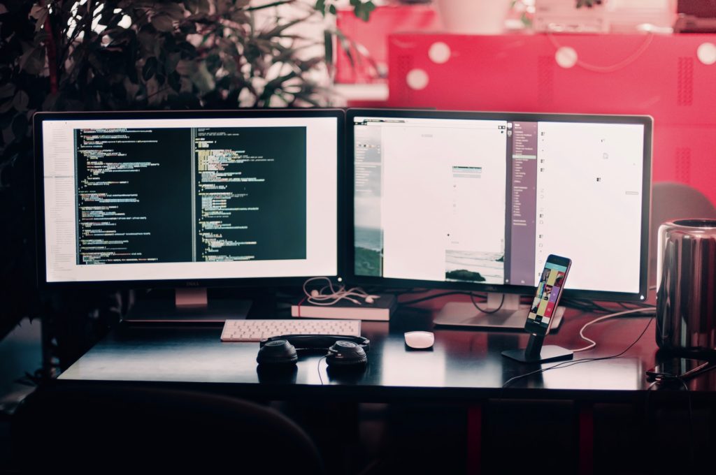 a computer monitor and a pair of headphones on a desk