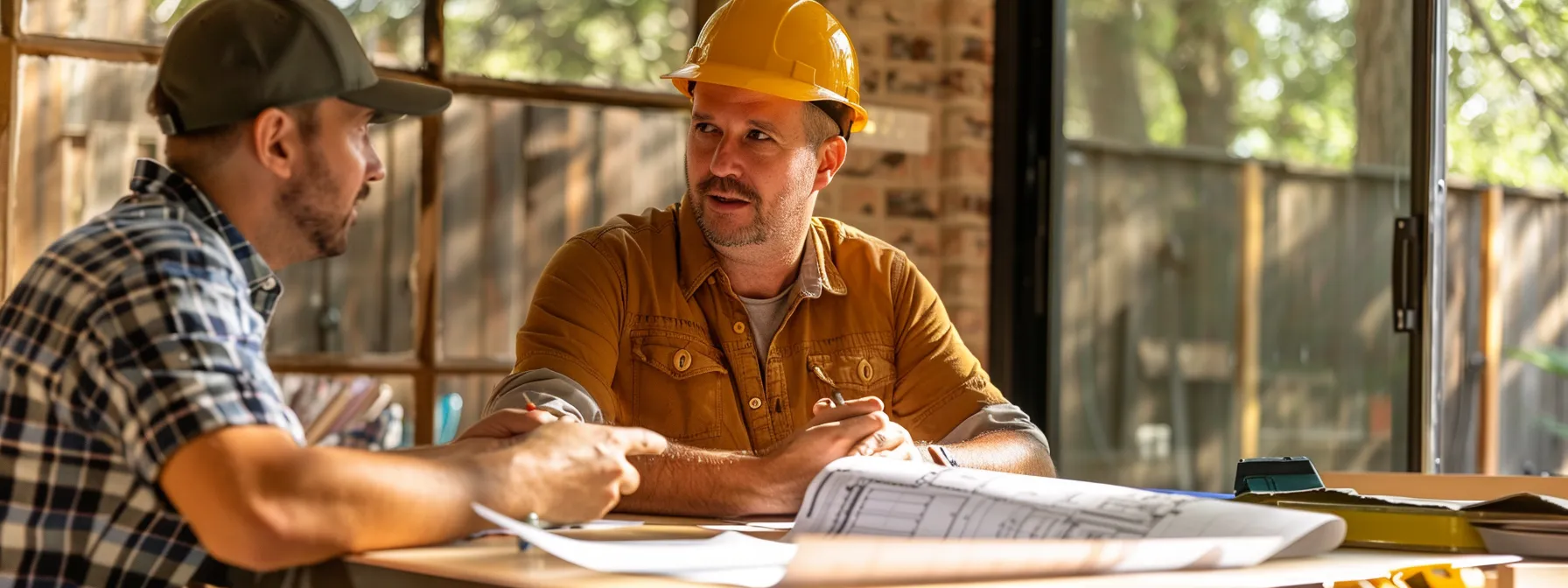 a homeowner sits at a table with a contractor, discussing renovation plans and looking at blueprints.